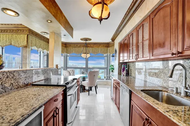 a kitchen with stainless steel appliances granite countertop a sink a stove and a wooden floors