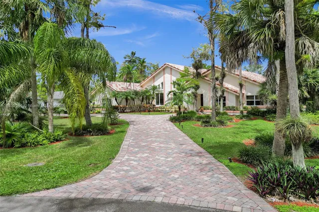 a front view of a house with a yard and potted plants