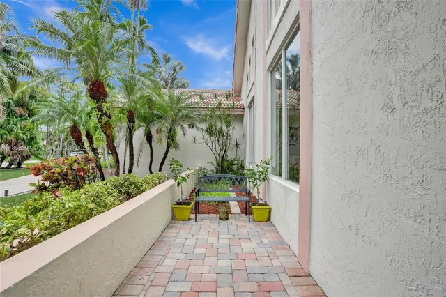 a living room with furniture a floor to ceiling window and kitchen view