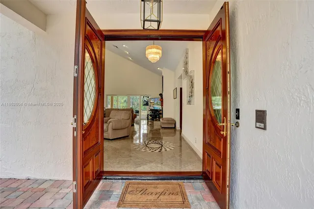 a living room with furniture kitchen view and a large window