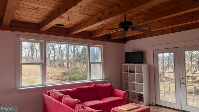 a living room with furniture a flat screen tv and a large window