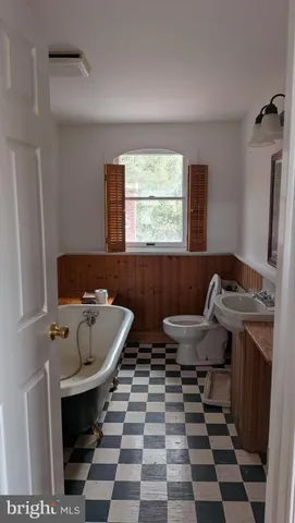 a bathroom with a sink a toilet and a window