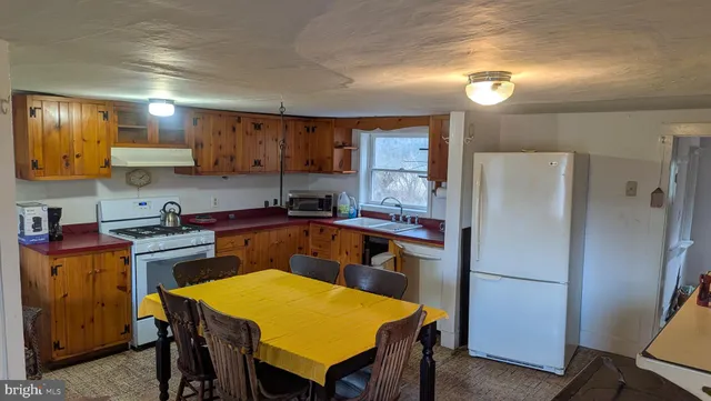 a kitchen with a table chairs refrigerator and microwave