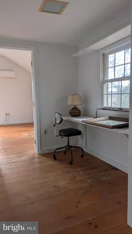a view of a workspace with furniture and a window