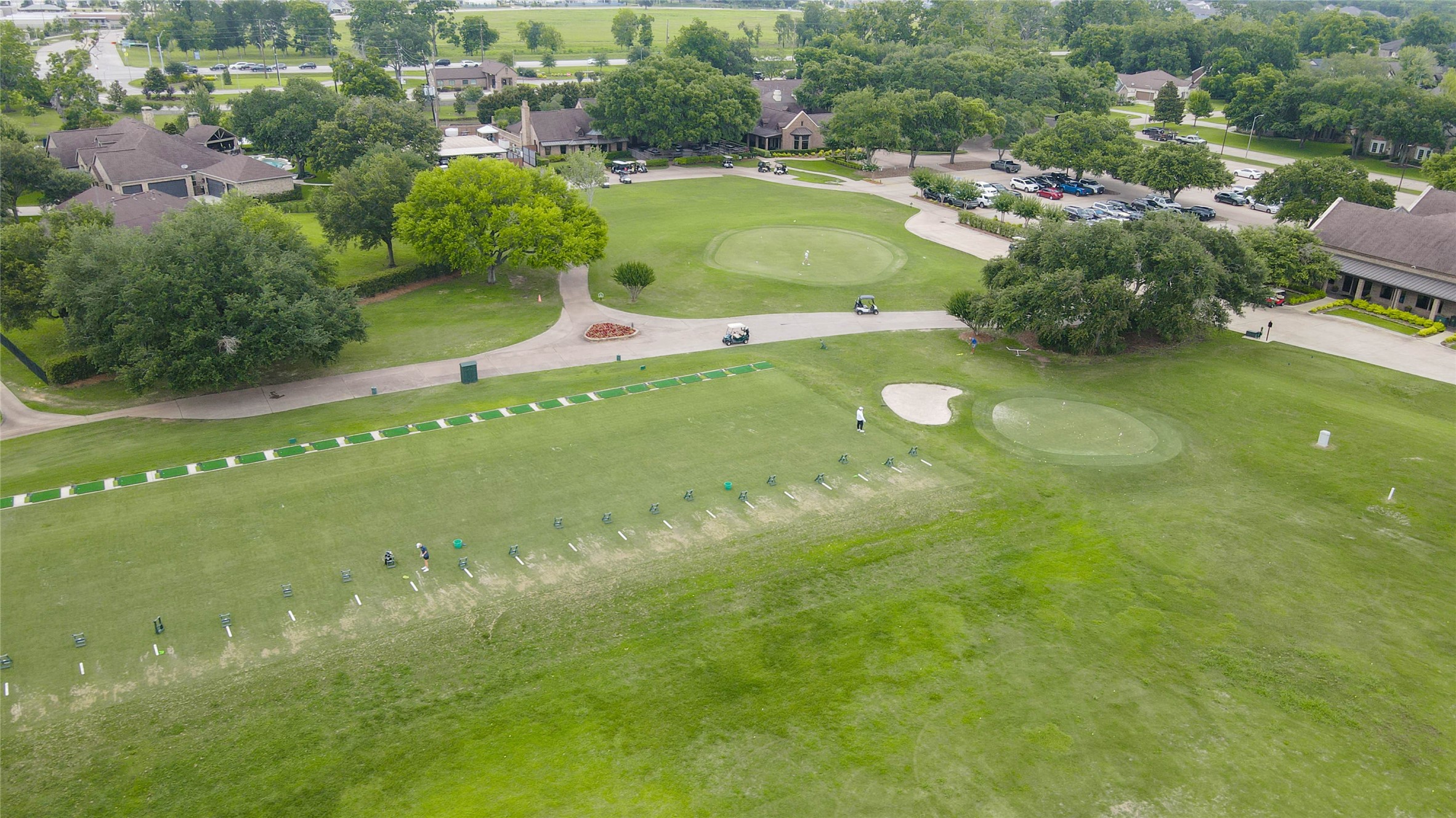 5327 Whitmore Fulshear, TX 77441 - Photo 48 of 50 This aerial view showcases part of the golf course practice area, featuring manicured greens, driving stations, and professionally maintained fairways.