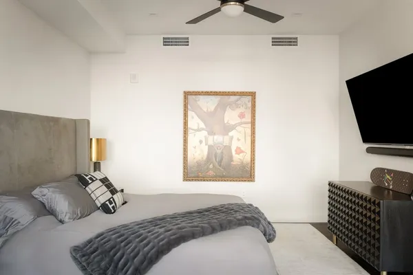 a bedroom with a large bed and a painting on the wall