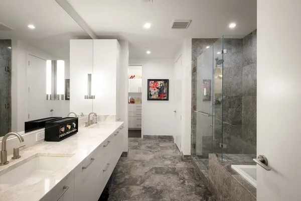 a bathroom with a granite countertop sink a bathtub and next to a window