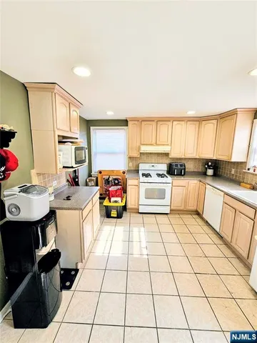 a kitchen with a sink a stove top oven cabinets and a window