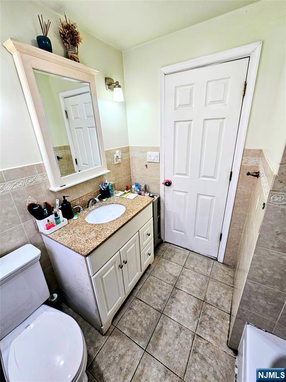 72 Front Street, Unit 2 North Arlington, NJ 07031 - Photo 9 of 14 a bathroom with a granite countertop toilet sink and mirror