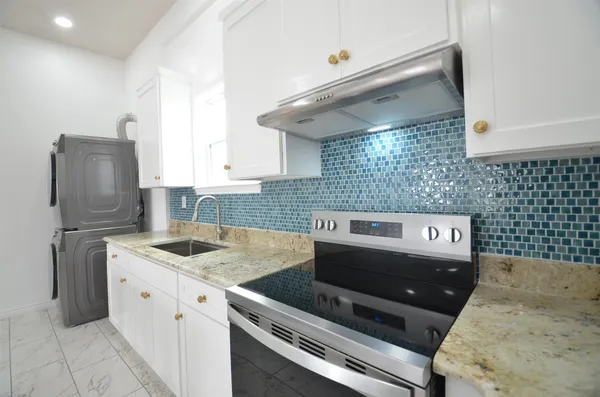 a kitchen with stainless steel appliances granite countertop a table chairs stove and refrigerator