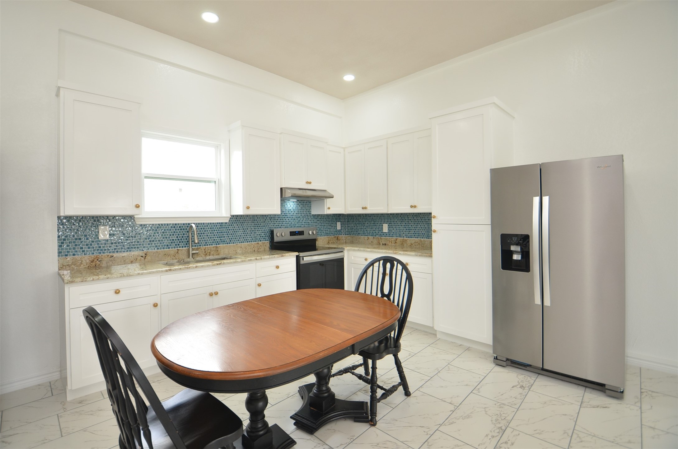 2002 West Airline County Road 55 Rosharon, TX 77583 - Photo 14 of 23 a kitchen with stainless steel appliances granite countertop a dining table chairs refrigerator and sink