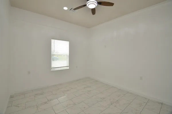 a kitchen with granite countertop a dining table chairs and a refrigerator