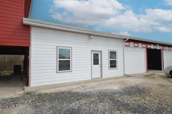 a view of house with backyard and glass windows