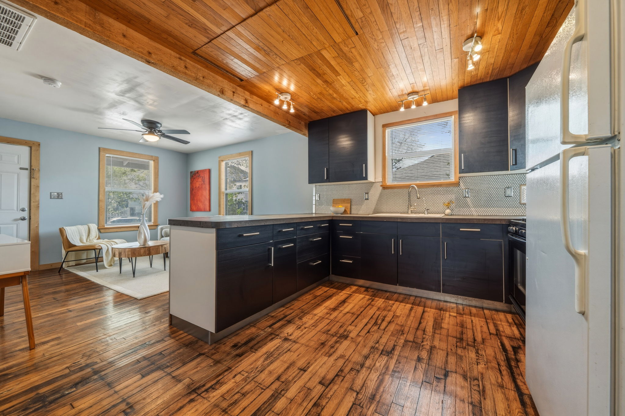 4806 Santa Anna Street Austin, TX 78721 - Photo 7 of 35 Kitchen featuring concrete counters, gas stove, microwave, freestanding refrigerator, and wood flooring & ceiling