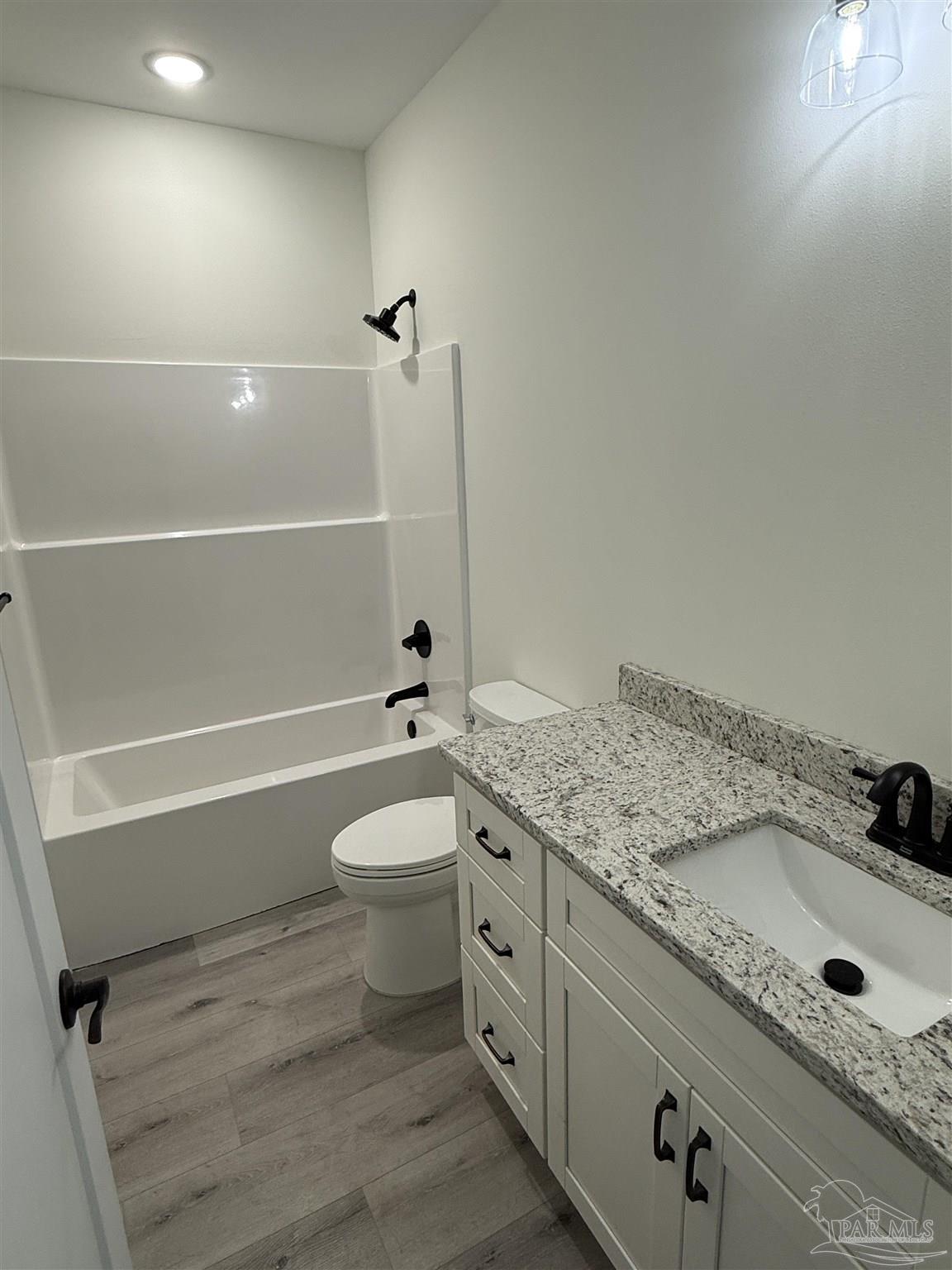 8636 Messick Street, Unit A Pensacola, FL 32534 - Photo 10 of 13 a bathroom with a granite countertop toilet a sink and bathtub