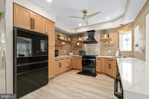 a large kitchen with granite countertop a stove cabinets and wooden floor