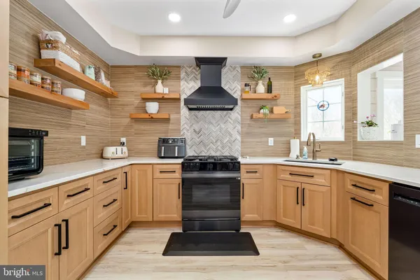 a kitchen with stainless steel appliances granite countertop a stove and white cabinets