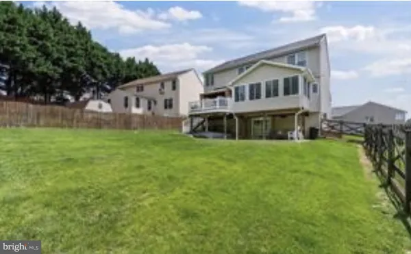 a view of a house with a big yard and large trees