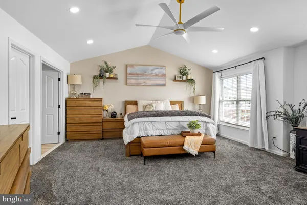 a living room with furniture a flat screen tv and a window