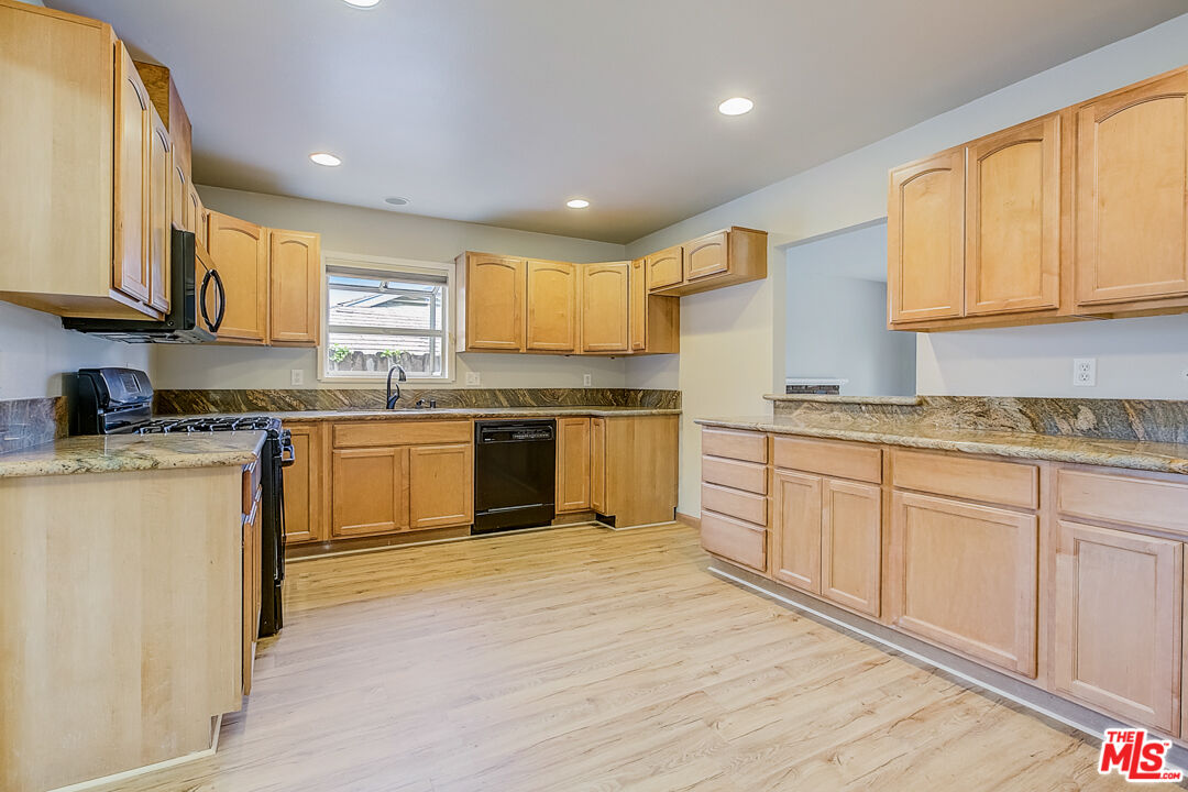 1817 Rolling Hills Drive Fullerton, CA 92835 - Photo 4 of 29 a kitchen with stainless steel appliances granite countertop a stove top oven a sink dishwasher and white cabinets with wooden floor