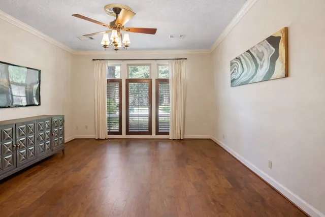 a view of an empty room with window and wooden floor