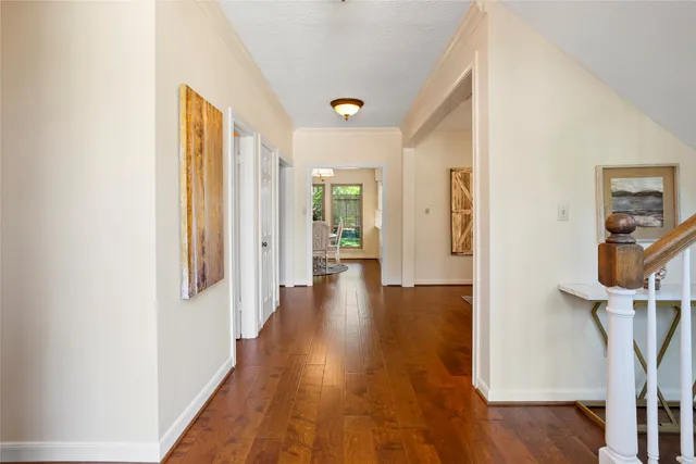 a view of a hallway with wooden floor and stairs
