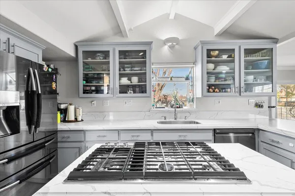 a kitchen with kitchen island a counter space a stove and a window