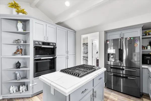 a kitchen with stainless steel appliances a refrigerator and a stove top oven