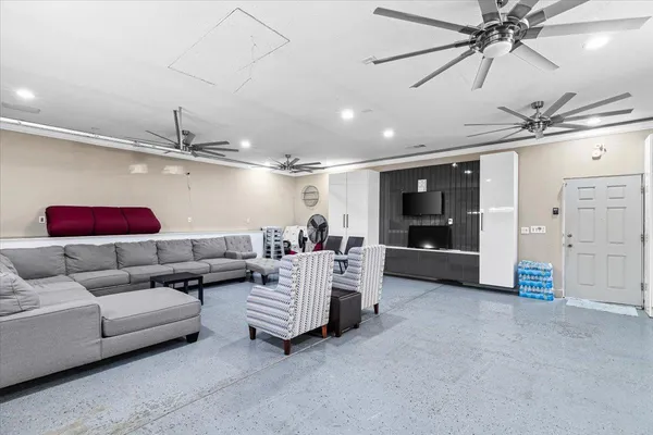 a living room with furniture and a ceiling fan