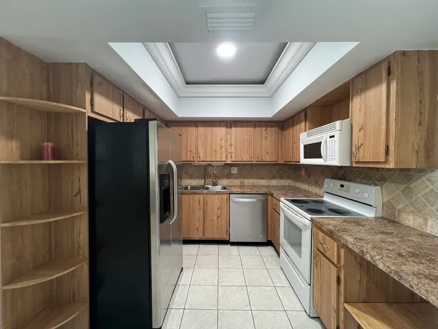 a kitchen with stainless steel appliances granite countertop a refrigerator and a sink