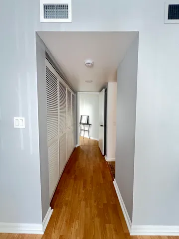 a view of hallway with wooden floor