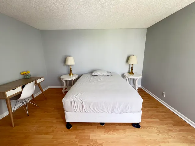 a bedroom with a bed and wooden floor