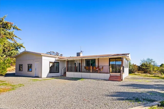 a front view of a house with a yard and potted plants