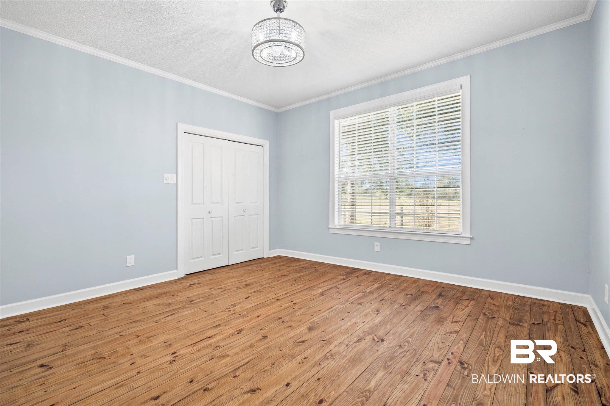 7650 Iron Rush Road Wilmer, AL 36587 - Photo 22 of 34 Unfurnished bedroom with ornamental molding, wood-type flooring, and a closet