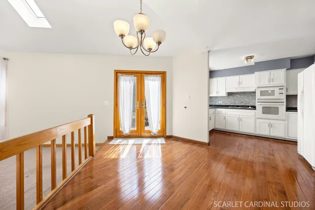 a view of a kitchen with wooden floor and stainless steel appliances