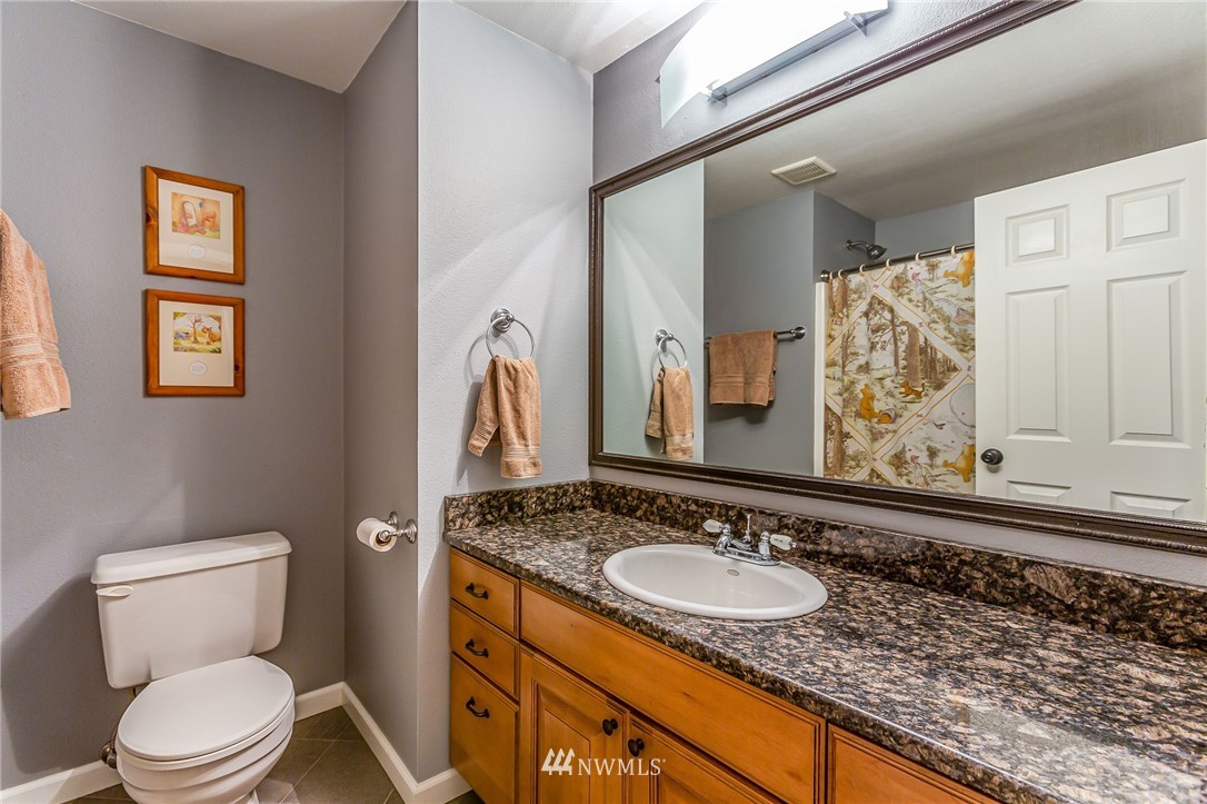 24229 15th Place Southeast Bothell, WA 98021 - Photo 23 of 40 a bathroom with a granite countertop sink vanity mirror bathtub and toilet