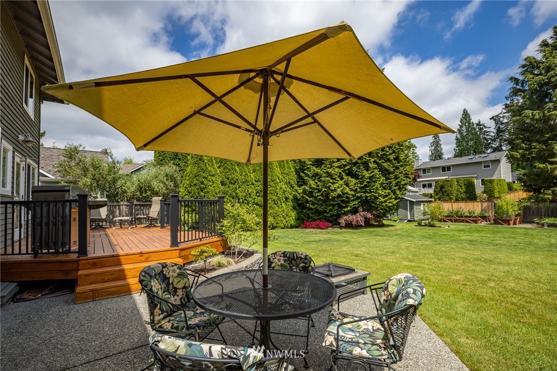 24229 15th Place Southeast Bothell, WA 98021 - Photo 29 of 40 a backyard of a house with table and chairs under an umbrella