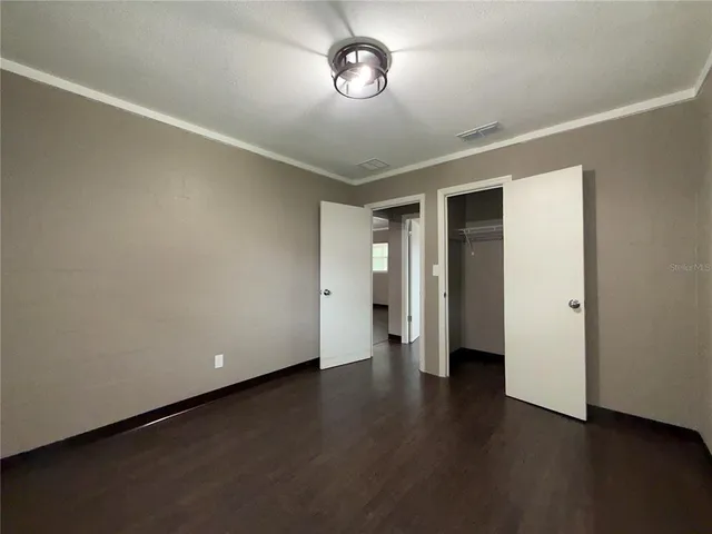 an empty room with wooden floor and window