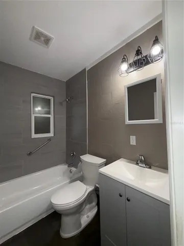 a bathroom with a toilet a sink a mirror and bathtub