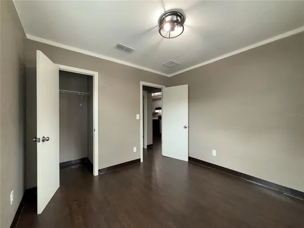 an empty room with wooden floor and window
