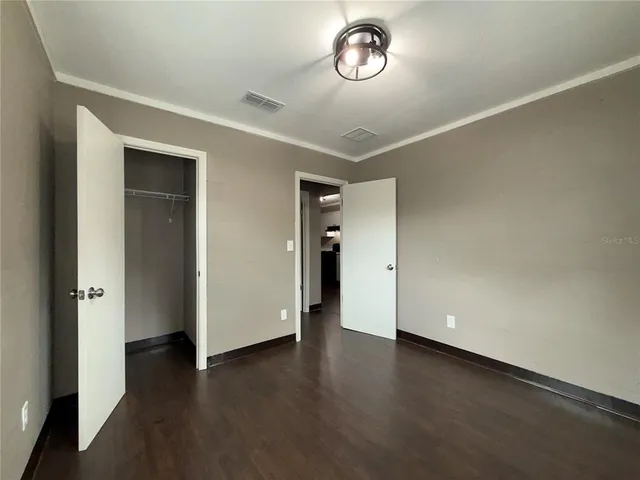 an empty room with wooden floor and window