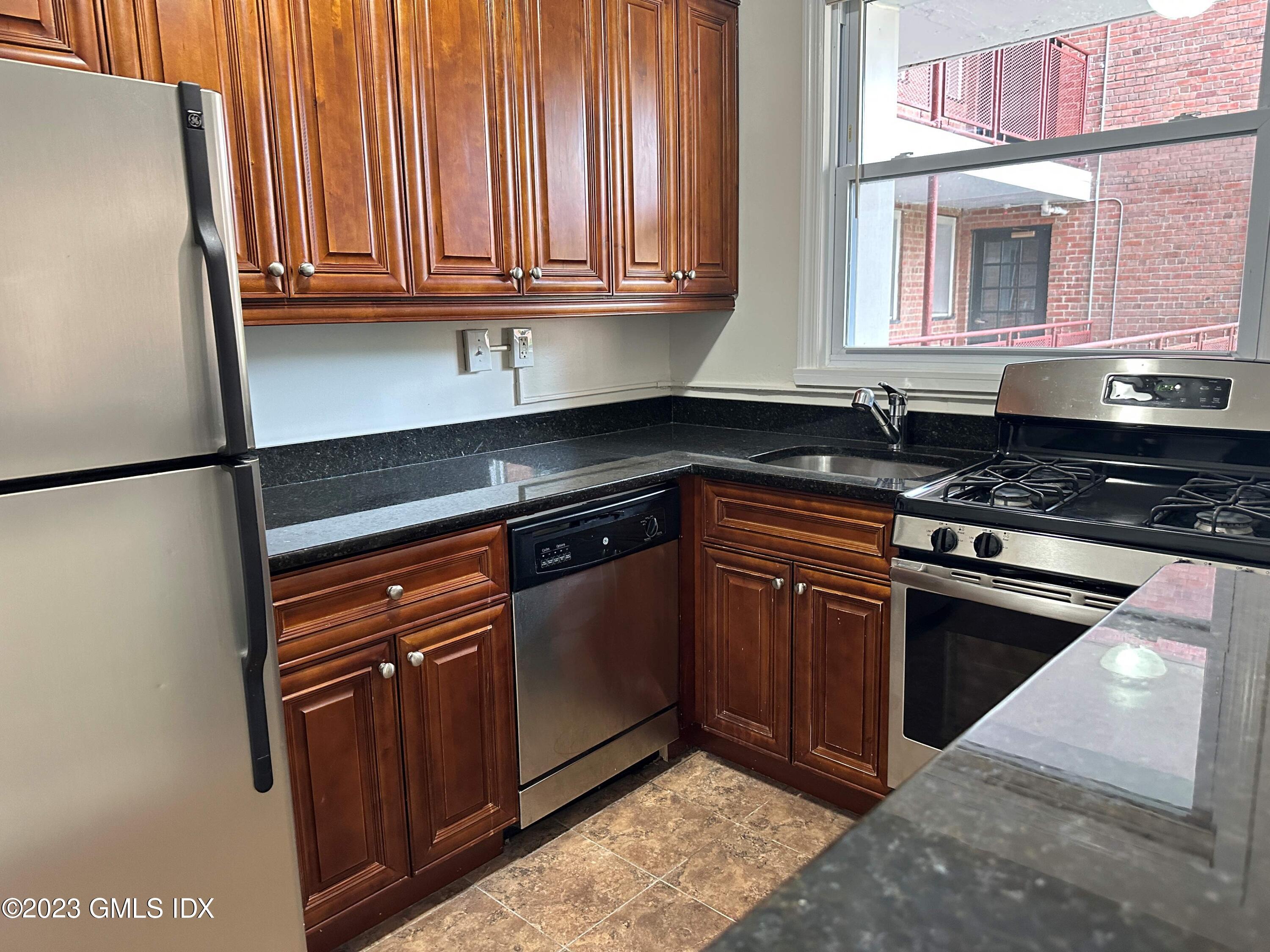 30 Brookside Drive, Unit 3G Greenwich, CT 06830 - Photo 4 of 17 a kitchen with granite countertop cabinets stainless steel appliances and a window