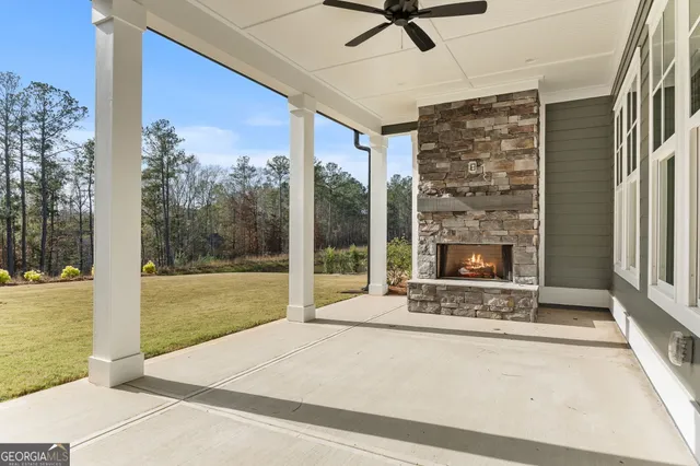 a large kitchen with granite countertop a large kitchen island white cabinetry and a wooden floor