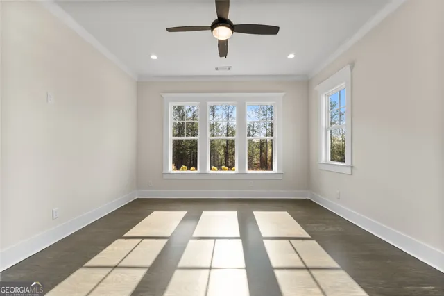 a view of an empty room with a window and wooden floor