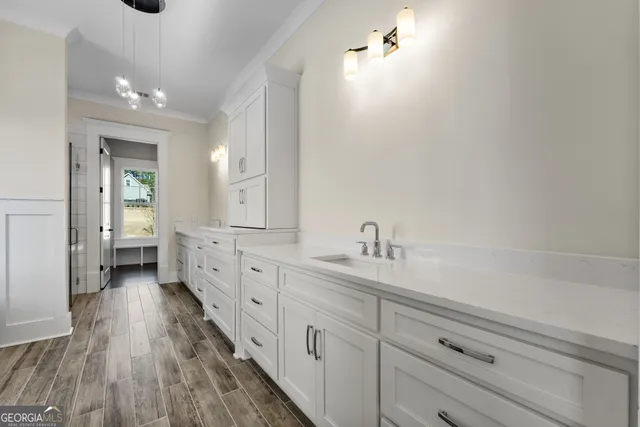 an empty room with wooden floor chandelier fan and windows