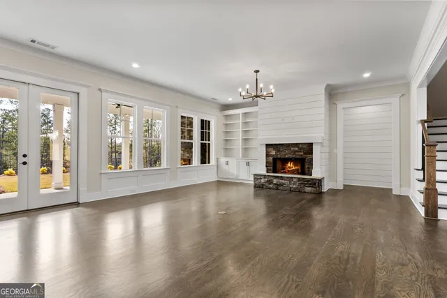 a view of an empty room with fire place and a window