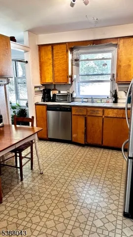a kitchen with stainless steel appliances granite countertop a stove a sink dishwasher and a refrigerator