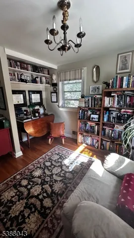 a bedroom with a bed a dresser with wooden floor
