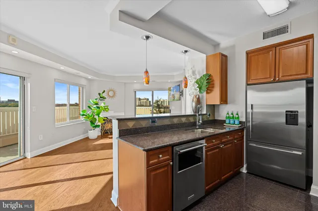 a kitchen with stainless steel appliances granite countertop a sink and a stove