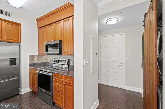 a kitchen with stainless steel appliances granite countertop a stove and a refrigerator